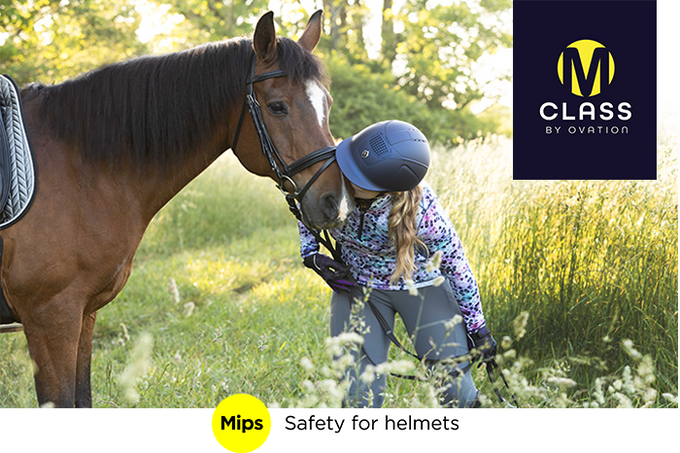  Rider wearing the Blue M Class Mips helmet while kissing her horse in the field 